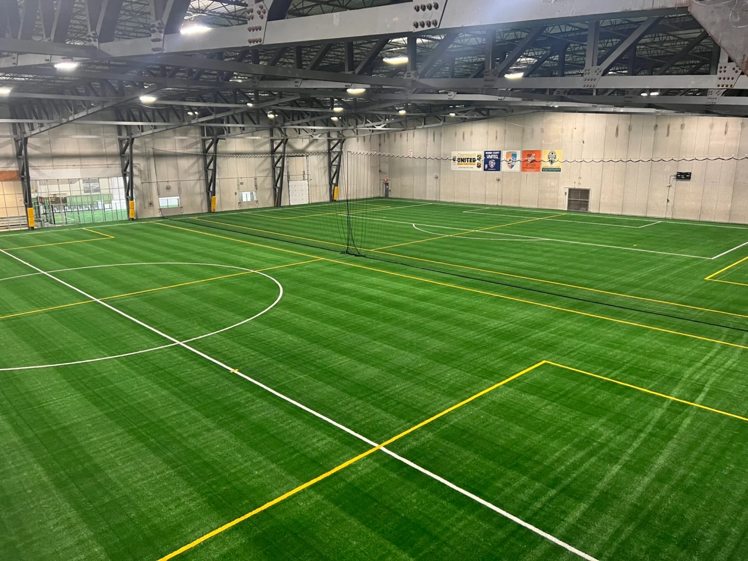 Wide view of an indoor multi-sport turf facility installed by TSS